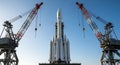Massive rocket being prepared for launch between two industrial cranes Royalty Free Stock Photo