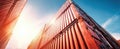 The towering shipping containers against a vibrant blue sky and sunlight. AI generated image Royalty Free Stock Photo