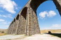 Towering sunlit arches of a railway viaduct, wide angle