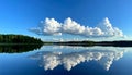 Expansive Blue Sky with Towering Clouds Reflected in a Still Lake reflection forest Royalty Free Stock Photo