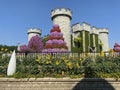 Towers in castle covered by plants and flowers, amazing colorful park, Miracle garden in Dubai