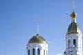 The towers of the Christian Church are white with golden domes and crosses on a blue sky background. Royalty Free Stock Photo