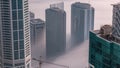 Rare early morning winter fog above the Dubai Marina skyline and skyscrapers rooftops aerial timelapse. Royalty Free Stock Photo