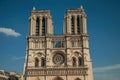 Towers and ornament on facade of gothic Notre-Dame Cathedral under sunny blue sky at Paris.