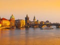 Towers of Prague Old Town and Charles Bridge over Vltava River illuminated by sunset