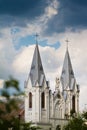 Towers and roof of Christian temple, St. Anna Roman Catholic Church in tender sunshine against heavy rainy clouds