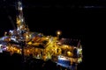 Towing of the oil platform. Oil platform at night in the light of its own lighting. Drilling platform in the port Royalty Free Stock Photo