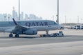 Towing tractor pushing airplane by Qatar airline on Doha International airport.