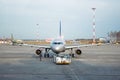 Towing truck pushing back passenger airplane business jet to the