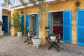 Town cozy cafe garden , with rustic wooden furniture and vibrant blue shutters.