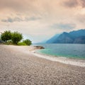 Town of Malcesine at Garda lake. Summer landscape with green trees, misty mountains and beautiful sky. Royalty Free Stock Photo