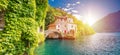 Town of Nesso historic stone bridge and scenic lakefront sun haze panoramic view Royalty Free Stock Photo