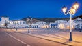 Town with numerous parked cars and pedestrians strolling in Mdiq, Morocco