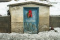 Door with peeling blue paint with holiday bough