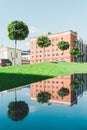 Town square with the office building in loft style. Large Windows. Red brick wall. Green trees and lawn on the left and Royalty Free Stock Photo