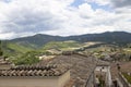 Town surrounded by high mountains covered in greens under the cloudy sky