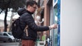 Townsman presses buttons on street vending machine