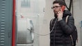 Townsman presses buttons on street telephone and talks
