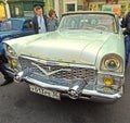 Townspeople around soviet luxury car of 1960-70s GAZ M13 Chaika