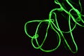 Toxic green lime lighting with a specific pattern. Woven filaments, cable, wires with outgoing light. Neon electroluminescent wire