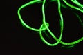 Toxic green lime lighting with a specific pattern. Woven filaments, cable, wires with outgoing light. Neon electroluminescent wire Royalty Free Stock Photo