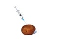 Potato pricked with a syringe on a white isolated background.