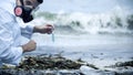 Toxicologist checking polluted water, splashing on shore, environmental disaster Royalty Free Stock Photo