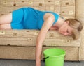 Toxicosis. The pregnant woman lies on a sofa with a bucket