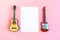 Toy acoustic and electric guitars and white mockup blank on pink background, top view Royalty Free Stock Photo