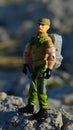 Toy action figure of GI Joe series named Rock N` Roll standing on guard on coastal rocks with rifle model in left hand