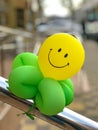 Toy air balloons in the form of a flower with a smile is greeting visitors at the entrance to the store Royalty Free Stock Photo