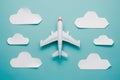 Toy airplane flying among white cloud cutouts on light blue background, playful and dreamy