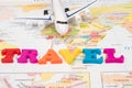 Toy airplane and the word travel made from colorful letters