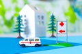 Toy ambulance car house tree blue green hospital sign background
