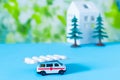 Toy ambulance car house tree blue green hospital sign background pills white