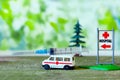 Toy ambulance car syringe blue green hospital sign background covid 19