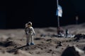 The toy of the astronaut stands on the moon\'s surface Royalty Free Stock Photo