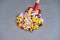 Toy baby scoop full of multi-colored pharmaceutical pills and capsules Royalty Free Stock Photo