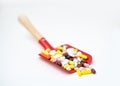 Toy baby scoop full of multi-colored pharmaceutical pills and capsules Royalty Free Stock Photo