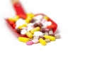 Toy baby scoop full of multi-colored pharmaceutical pills and capsules Royalty Free Stock Photo