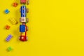 Toy background. Wooden toy train and colorful building brick blocks on yellow background