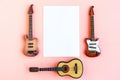 Toy bass, acoustic and electric guitars and white mockup blank on pink background Royalty Free Stock Photo