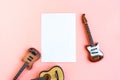 Toy bass, acoustic and electric guitars and white mockup blank on pink background Royalty Free Stock Photo