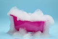 Toy bathtub overflowing with foam on light blue background Royalty Free Stock Photo
