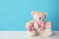 Toy bear with stethoscope and pills on table against color background. Children`s hospital