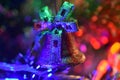 Toy bell on the background of bright festive lights, blurred image