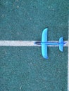 Toy blue airplane on grey background with white stripe background. Miniature toy airplane on blue background Royalty Free Stock Photo