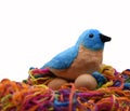 A toy blue and brown bird with a black beak is nesting on two brown eggs Royalty Free Stock Photo