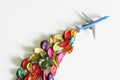 Toy blue passenger airliner with a contrail of colorful flower petals. Concept of eco-friendly biofuel, alternative energy and