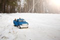 A toy. Blue pickup truck in winter forest with open door on the road. Carrying fir cones in the back of a car body Royalty Free Stock Photo